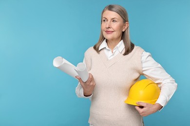 Photo of Architect with hard hat and drafts on light blue background, space for text