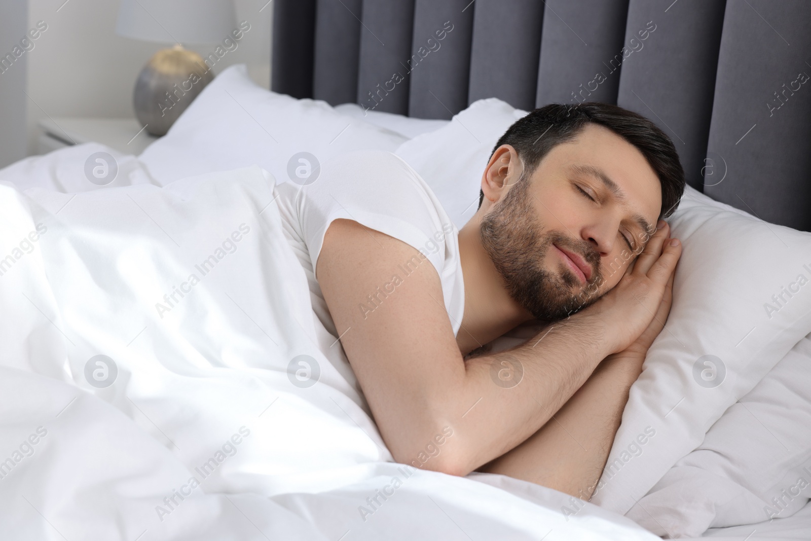 Photo of Handsome man sleeping in soft bed at home