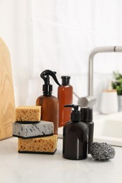 Photo of Different cleaning supplies on countertop in kitchen