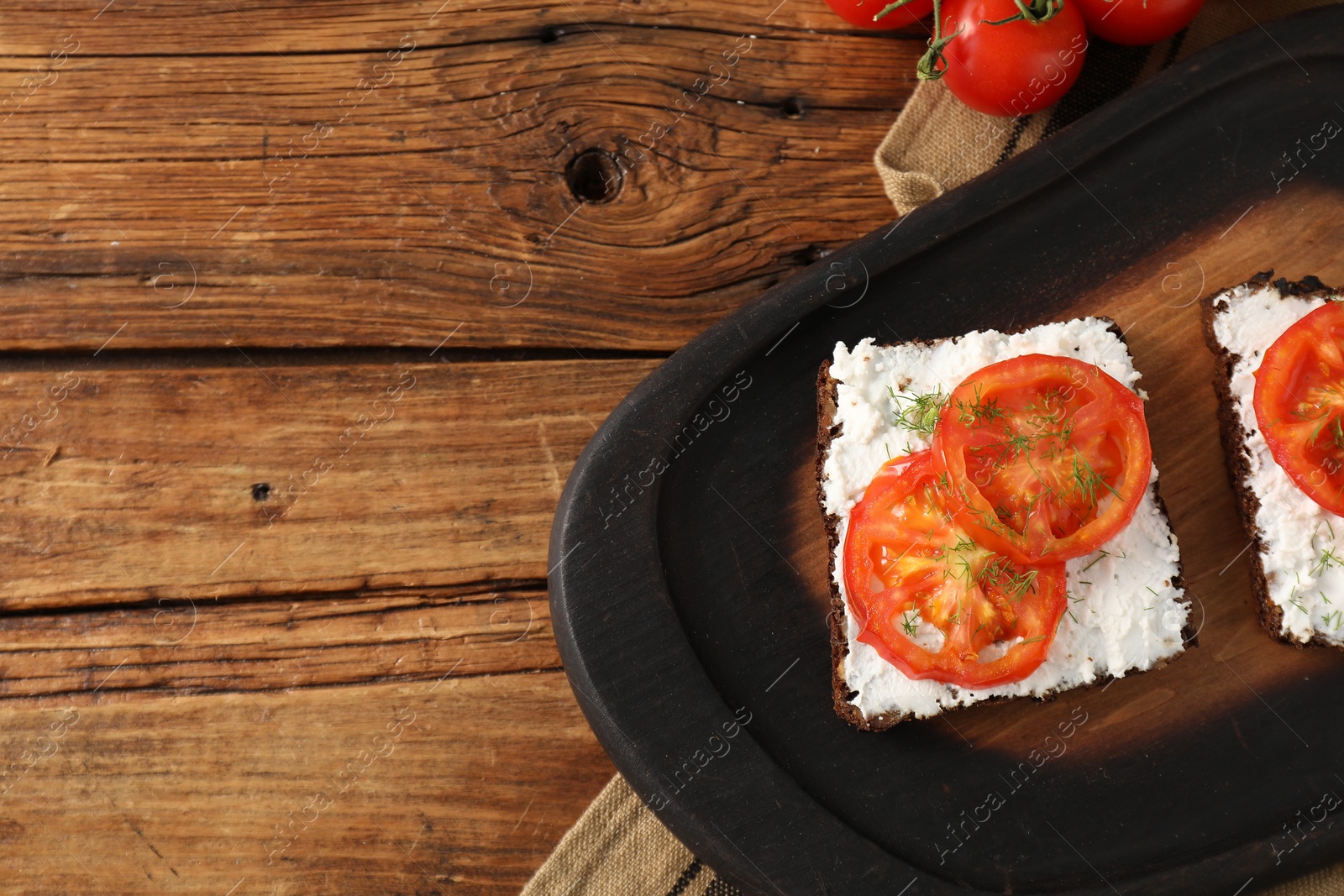 Photo of Delicious ricotta bruschettas with sliced tomatoes and dill on wooden table, flat lay. Space for text