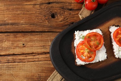 Delicious ricotta bruschettas with sliced tomatoes and dill on wooden table, flat lay. Space for text