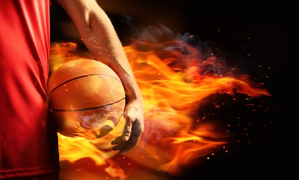 Image of Basketball player with ball in flame on black background, closeup