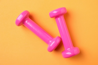 Bright dumbbells on color background, flat lay. Home fitness