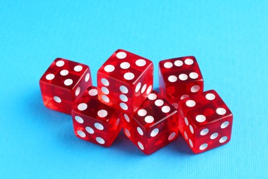 Photo of Many red game dices on light blue background