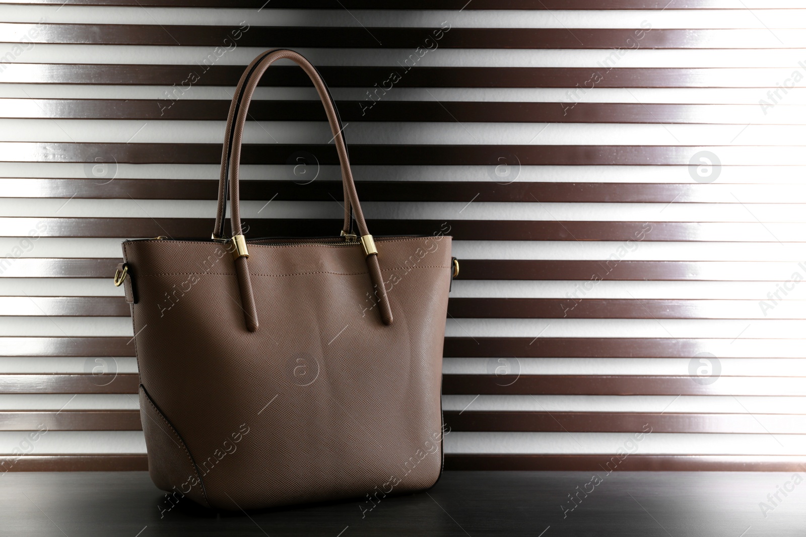 Photo of Stylish woman's bag on dark grey table. Space for text