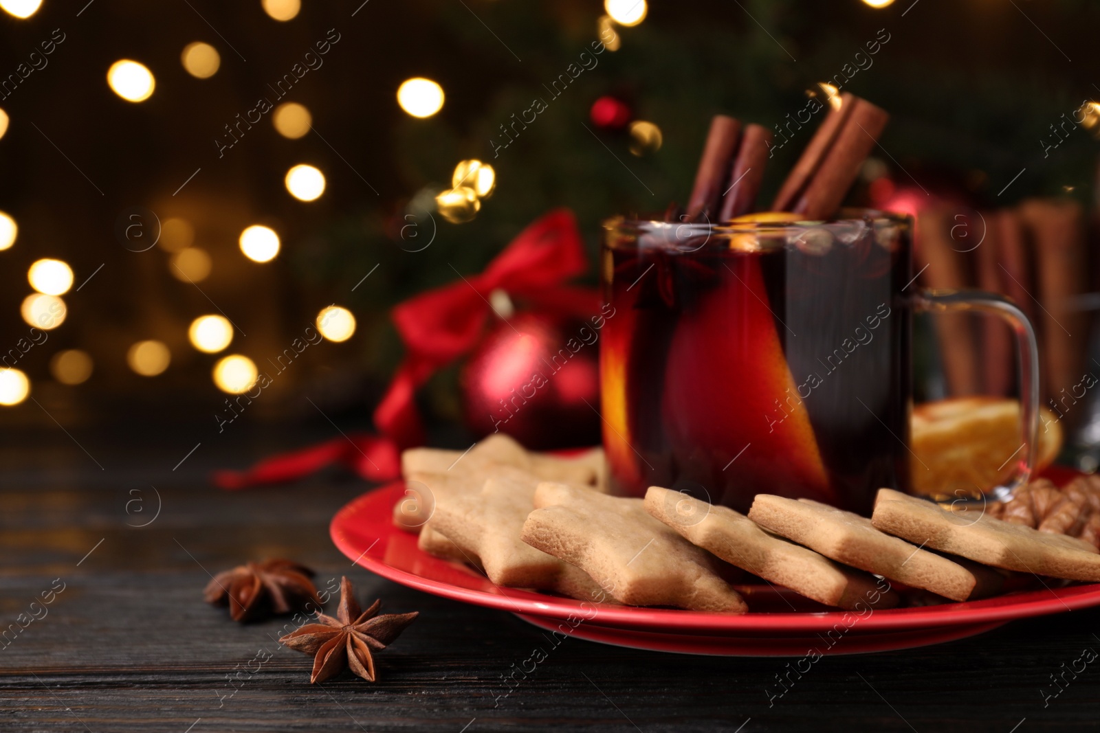 Photo of Aromatic mulled wine and cookies on wooden table, closeup. Space for text