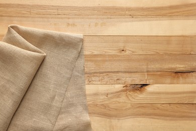 Photo of Burlap fabric on wooden table, top view. Space for text