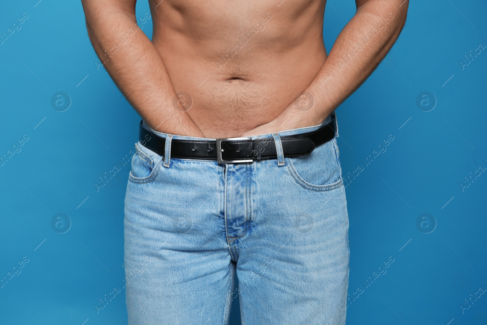 Photo of Man scratching crotch on color background, closeup. Annoying itch