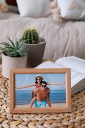 Framed photo of happy couple on wicker table in living room