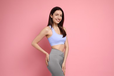 Photo of Happy young woman with slim body on pink background