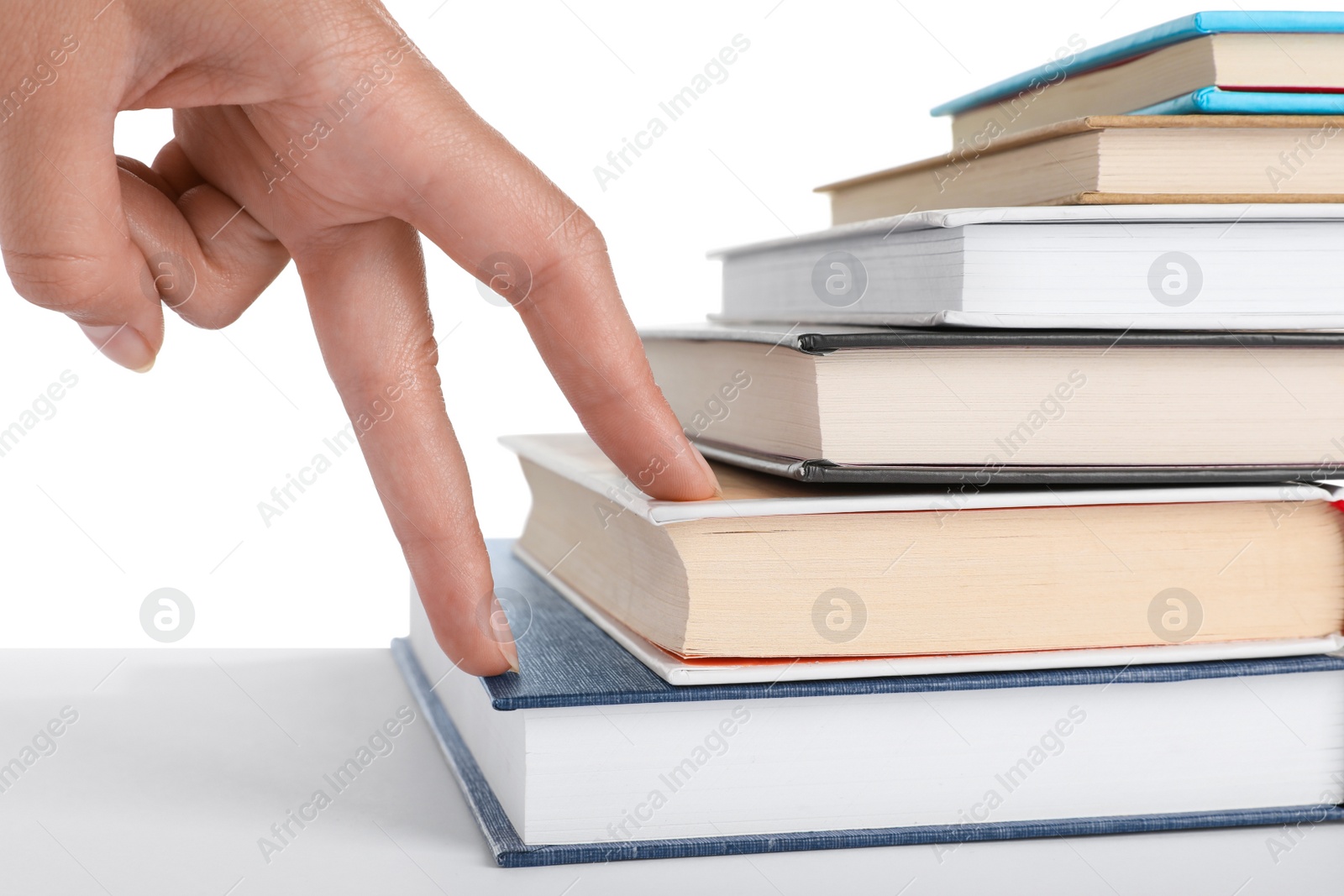 Photo of Woman imitating stepping up on books with her fingers against white background, closeup