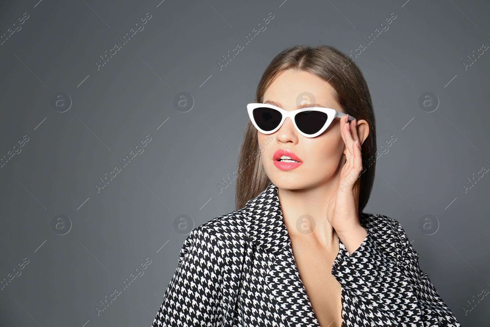 Photo of Young woman wearing stylish sunglasses on grey background. Space for text