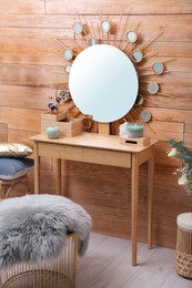Photo of Dressing table with decor near wooden wall in room