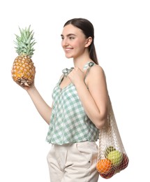 Photo of Woman with string bag of fresh fruits holding pineapple on white background