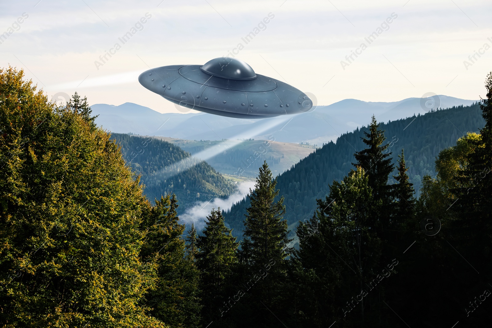 Image of Alien spaceship flying over trees in mountains. UFO