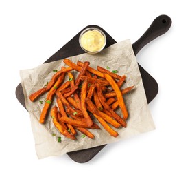 Board with delicious sweet potato fries and sauce on white background