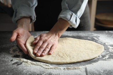 Photo of Woman making pizza dough at table, closeup