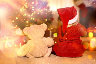 Image of Baby wearing Santa hat and teddy bear in room decorated for Christmas, back view. Magical festive atmosphere