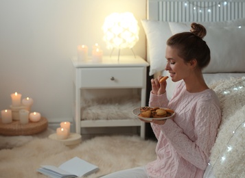 Photo of Young woman with tasty cookies at home. Cozy winter