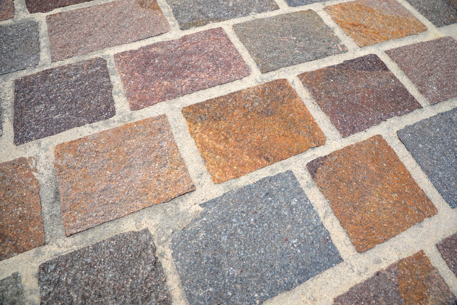 Photo of Pavement made of tiles as background, closeup