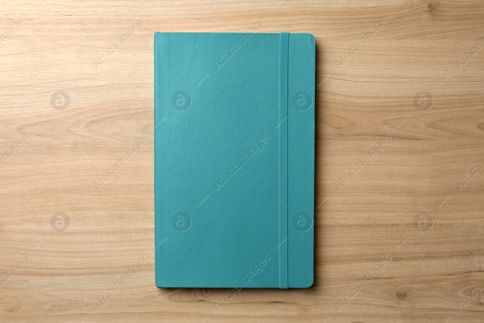 Photo of Turquoise planner on wooden table, top view