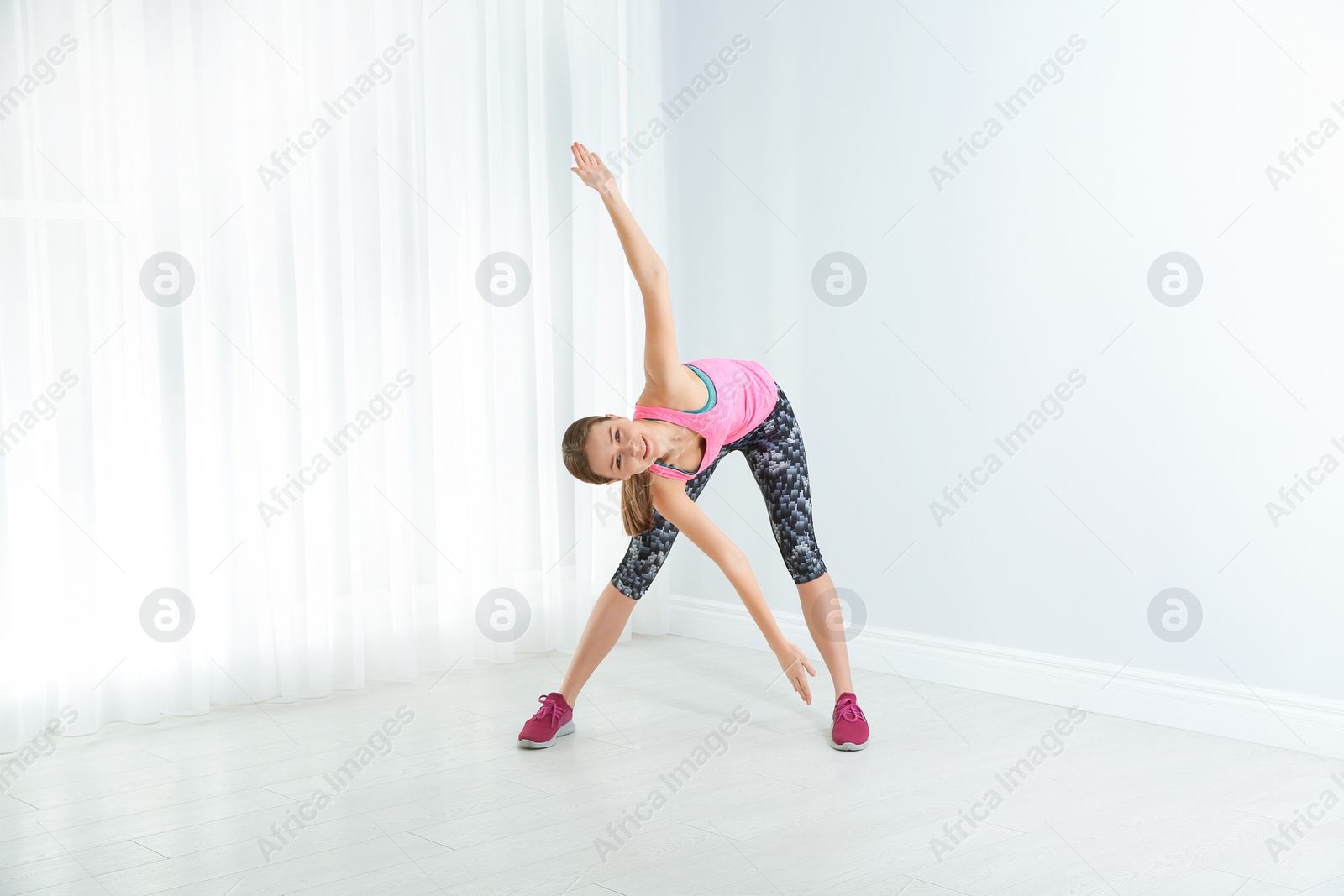 Photo of Young woman doing fitness exercises at home