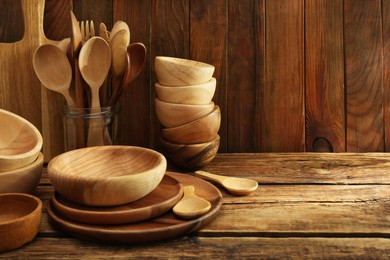 Many different wooden dishware and utensils on table. Space for text