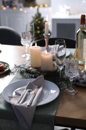 Photo of Christmas table setting with festive decor and dishware indoors