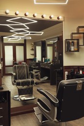 Photo of Stylish hairdresser's workplace with professional armchair in barbershop