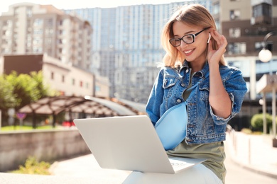 Photo of Beautiful woman using laptop in city on sunny day