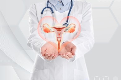 Image of Doctor demonstrating virtual icon with illustration of female reproductive system on light background, closeup. Gynecological care 