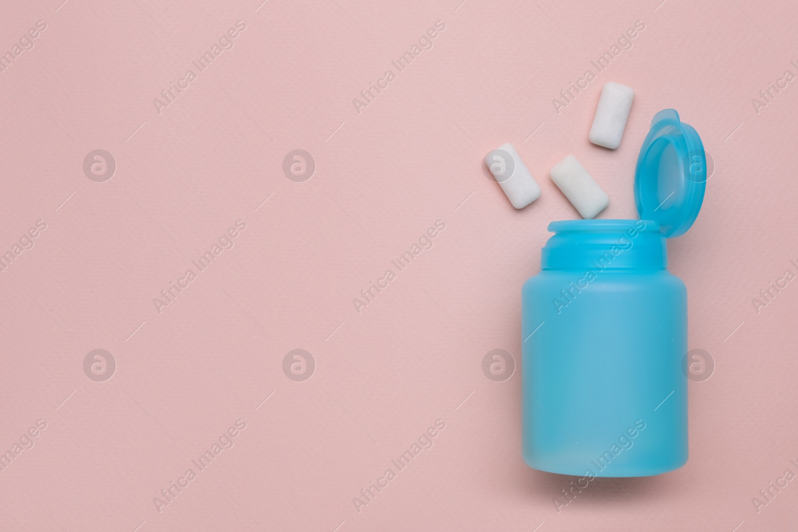 Photo of Jar with chewing gums on light pink background, flat lay. Space for text