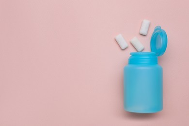 Jar with chewing gums on light pink background, flat lay. Space for text