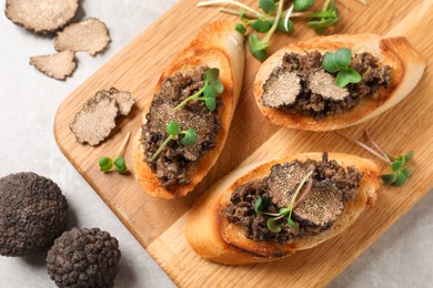 Photo of Tasty bruschettas with truffle paste on grey table, flat lay