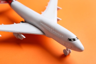 Photo of Toy airplane on orange background, closeup view