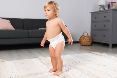 Cute baby learning to walk in living room