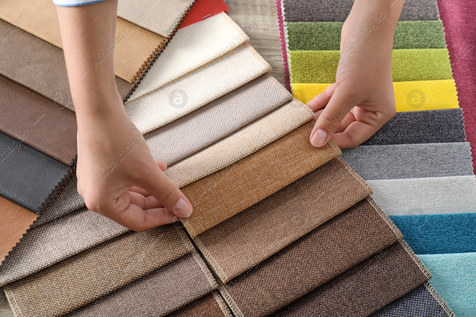 Photo of Young woman choosing among upholstery fabric samples, closeup. Interior design