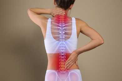 Image of Woman suffering from pain in back on beige background, closeup