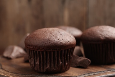 Photo of Delicious chocolate cupcake on wooden board, closeup