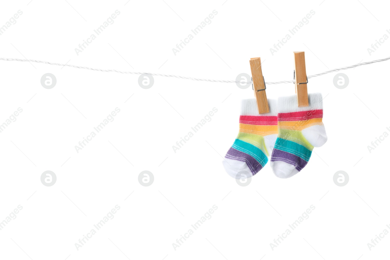 Photo of Cute child socks on laundry line against white background