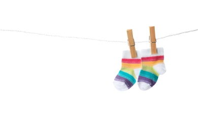 Cute child socks on laundry line against white background