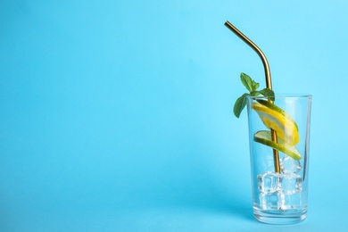 Photo of Glass with ice, straw, citrus slices and mint on color background, space for text. Summer cocktail recipe