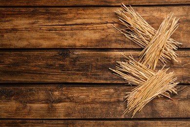 Photo of Dried hay on wooden background, flat lay. Space for text