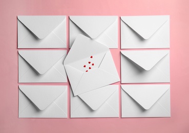 Photo of Envelopes and heart shaped sprinkles on pink background, flat lay. Love letters