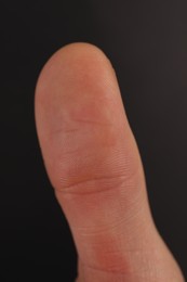 Photo of Man scanning fingerprint on black background, closeup