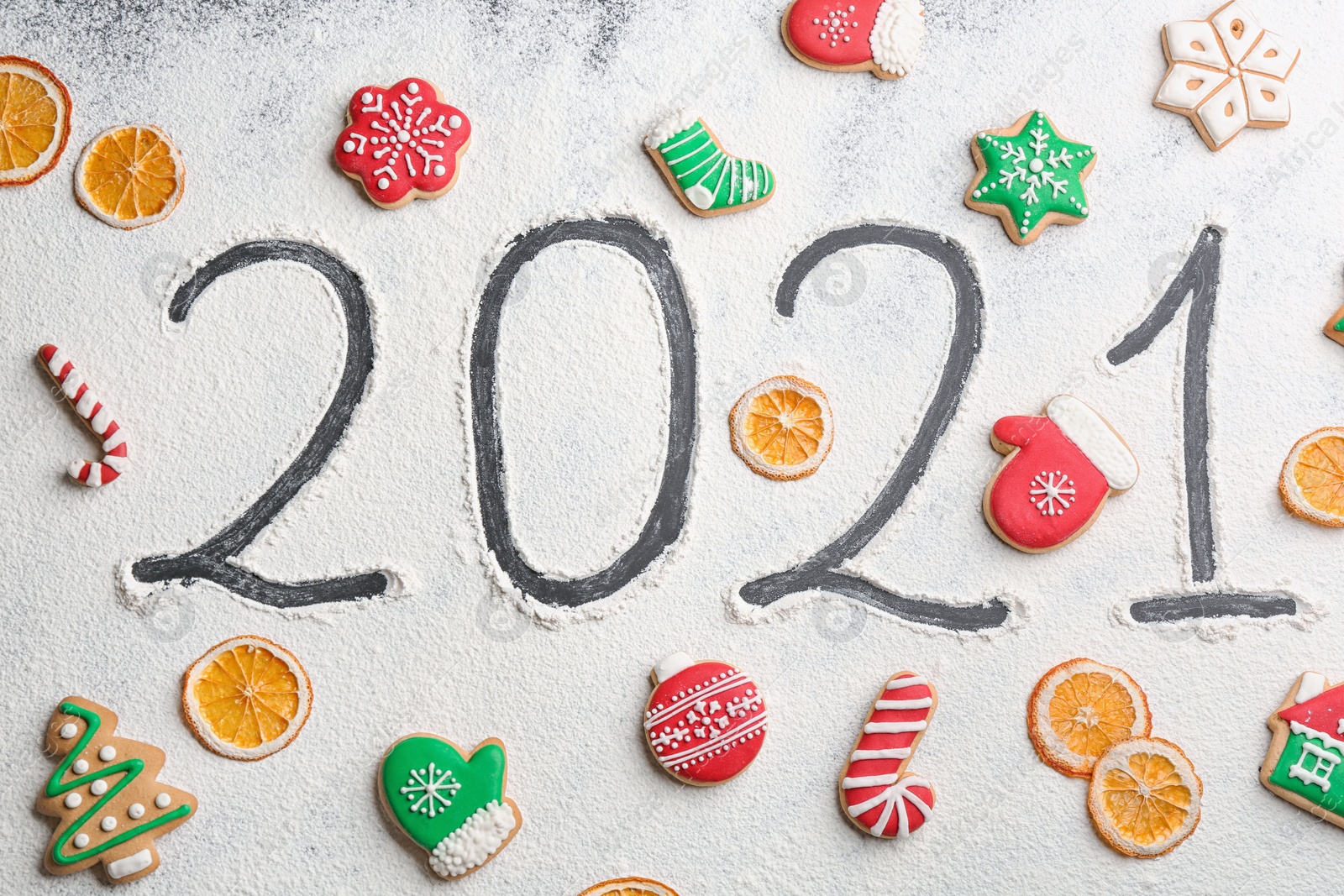 Photo of Tasty homemade Christmas cookies and number 2021 made of flour on table, flat lay