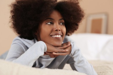 Photo of Smiling African American woman on bed at home