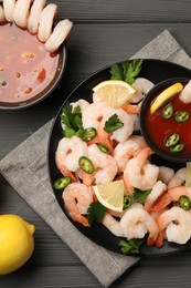 Tasty boiled shrimps with cocktail sauce, chili, parsley and lemon on grey wooden table, flat lay