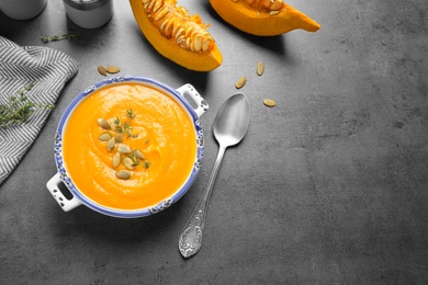 Delicious pumpkin soup in bowl on grey table, flat lay. Space for text