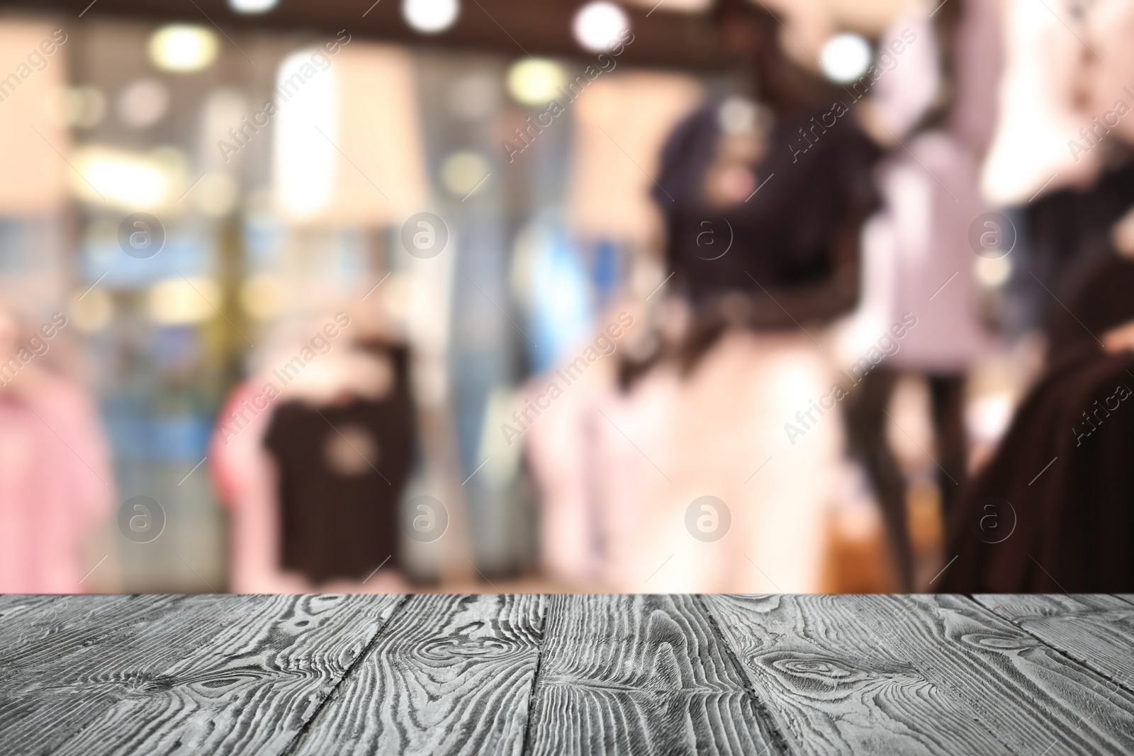 Image of Empty wooden table and blurred view of store with modern clothes